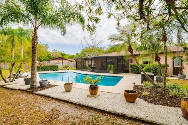 view of swimming pool featuring a fenced in pool, fence, a patio, and a sunroom