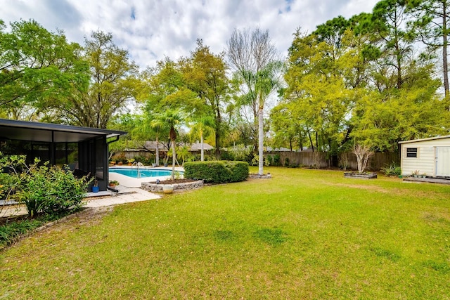 view of yard with a shed, a fenced in pool, an outdoor structure, and a fenced backyard