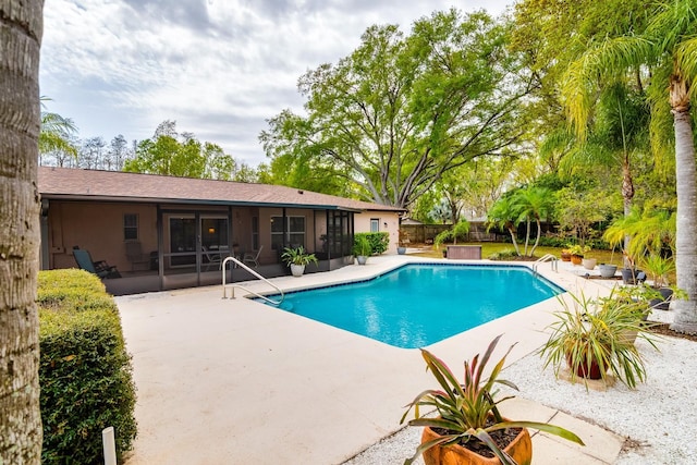 view of pool featuring a patio area, a fenced in pool, fence, and a sunroom