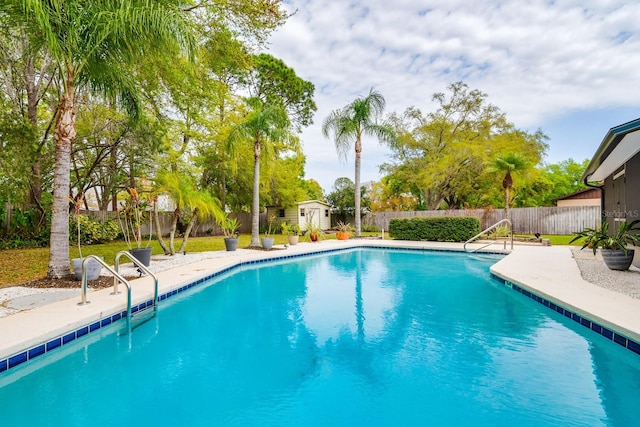 view of pool with a fenced in pool, a storage unit, and a fenced backyard