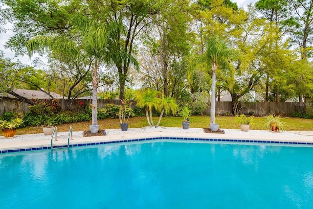 view of swimming pool featuring a yard, a fenced in pool, and a fenced backyard