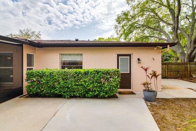 exterior space with a patio area, stucco siding, and fence