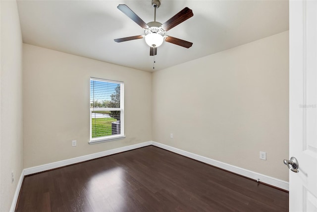 spare room featuring ceiling fan, baseboards, and dark wood finished floors