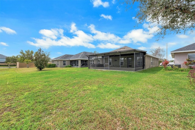 back of house with a lawn and a sunroom