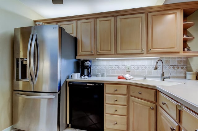 kitchen featuring light brown cabinets, a sink, black dishwasher, tasteful backsplash, and stainless steel fridge