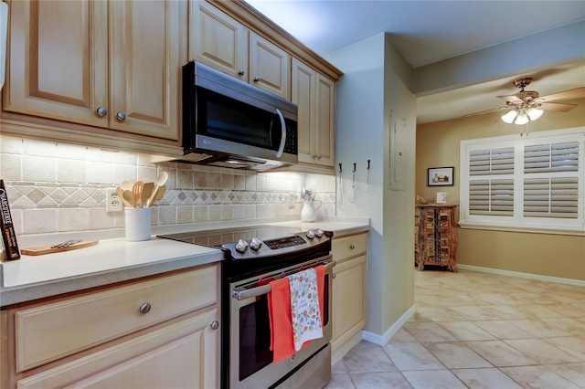 kitchen featuring appliances with stainless steel finishes, light countertops, decorative backsplash, baseboards, and ceiling fan