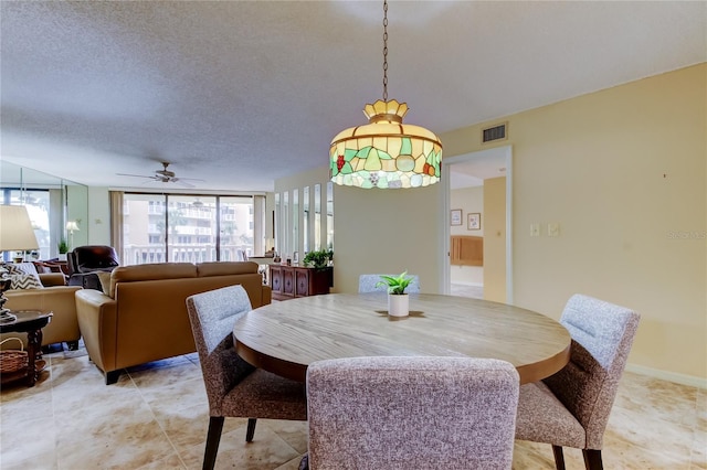 dining space featuring baseboards, visible vents, and a textured ceiling