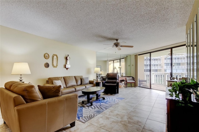 living area featuring expansive windows, light tile patterned flooring, a ceiling fan, and a textured ceiling