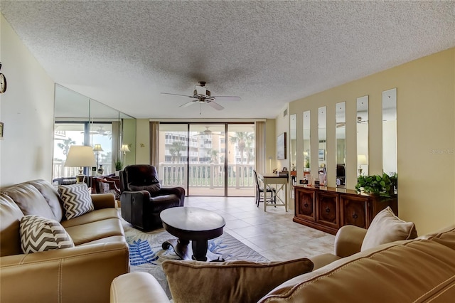 living area with light tile patterned floors, a textured ceiling, ceiling fan, and expansive windows