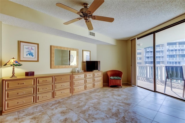 unfurnished room with light tile patterned floors, visible vents, ceiling fan, floor to ceiling windows, and a textured ceiling