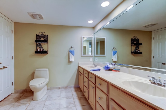 full bathroom with double vanity, toilet, baseboards, and a sink