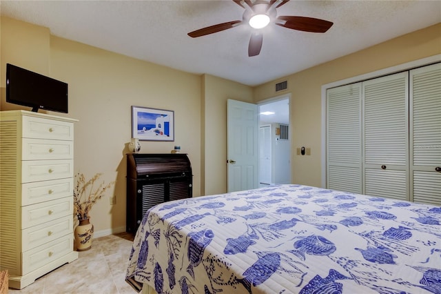 bedroom featuring visible vents, baseboards, ceiling fan, light tile patterned floors, and a closet