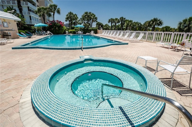 pool with a patio and a community hot tub