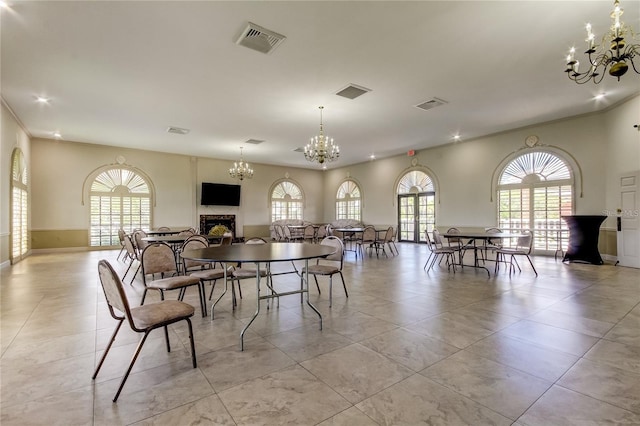 dining space with visible vents, a chandelier, and a fireplace