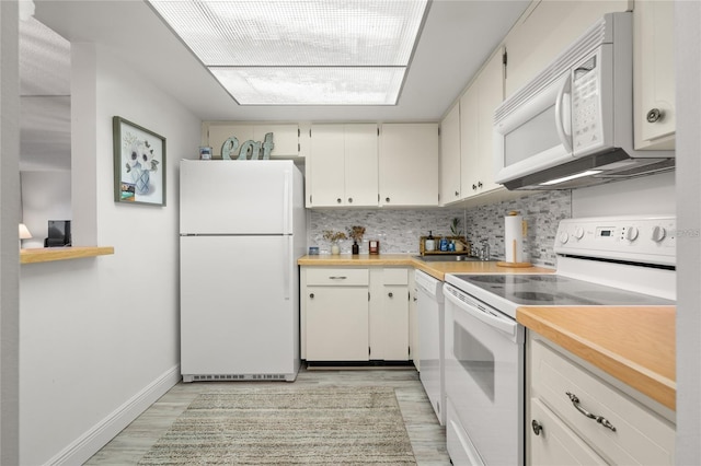 kitchen with tasteful backsplash, white appliances, light wood-type flooring, and light countertops