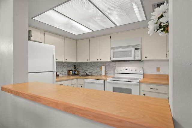 kitchen featuring tasteful backsplash, light countertops, white appliances, white cabinetry, and a sink