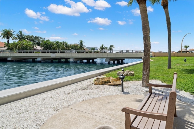 view of dock with a lawn and a water view