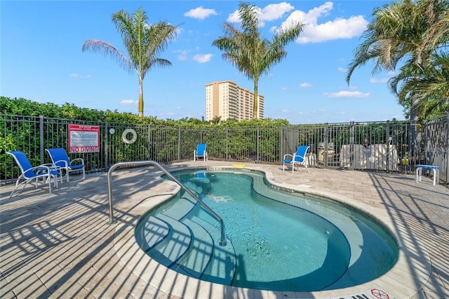 view of swimming pool with a patio and fence