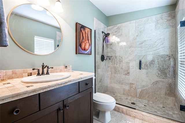 bathroom featuring a shower stall, toilet, and vanity