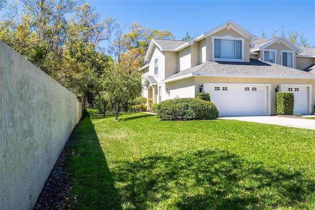 view of home's exterior featuring fence, a yard, an attached garage, stucco siding, and concrete driveway