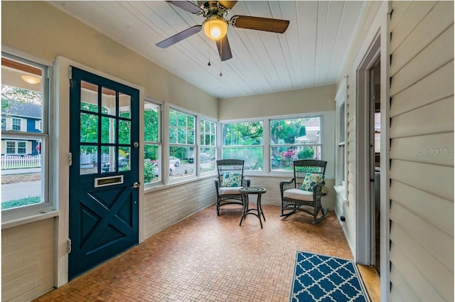 sunroom with wood ceiling and a ceiling fan