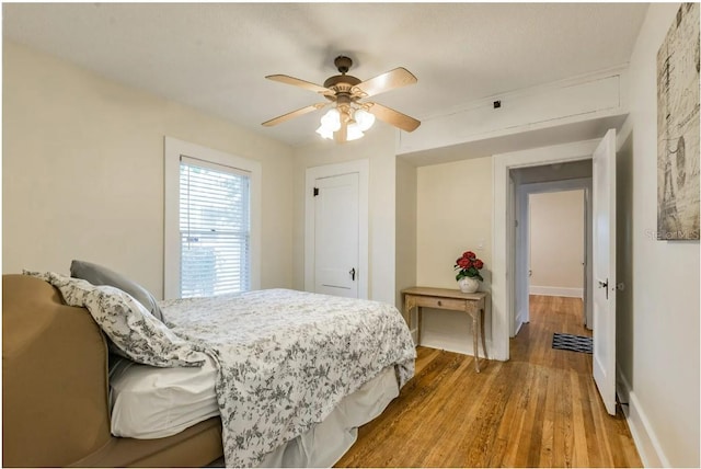 bedroom featuring visible vents, baseboards, wood finished floors, and a ceiling fan