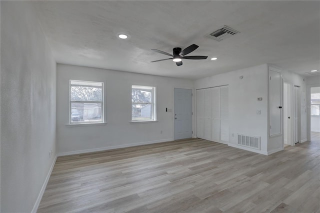 unfurnished room featuring visible vents, light wood-style flooring, and baseboards