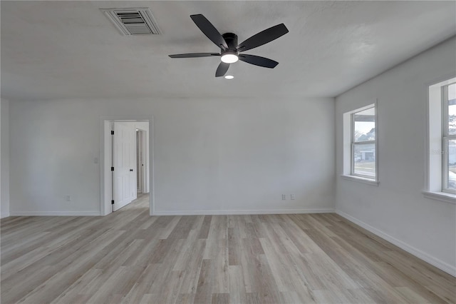 empty room featuring visible vents, light wood-style flooring, and baseboards