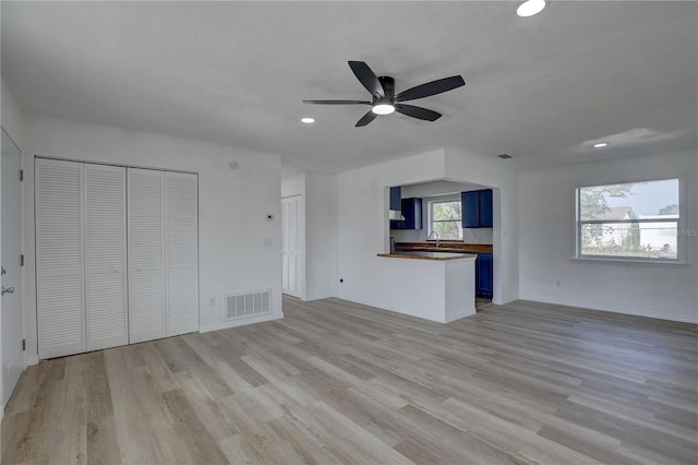 unfurnished living room featuring visible vents, recessed lighting, light wood-type flooring, and a sink