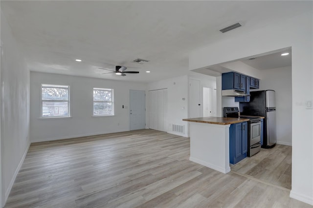 kitchen with light wood finished floors, visible vents, blue cabinetry, stainless steel appliances, and wood counters