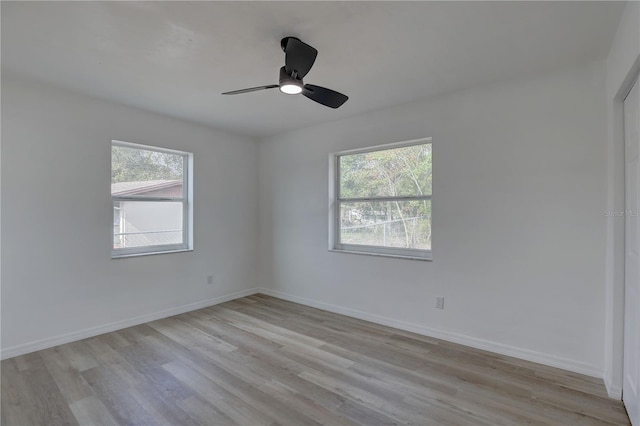 unfurnished room with light wood-style flooring, plenty of natural light, a ceiling fan, and baseboards