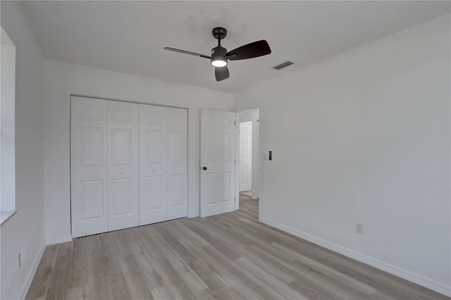 unfurnished bedroom featuring visible vents, baseboards, light wood-type flooring, a closet, and a ceiling fan