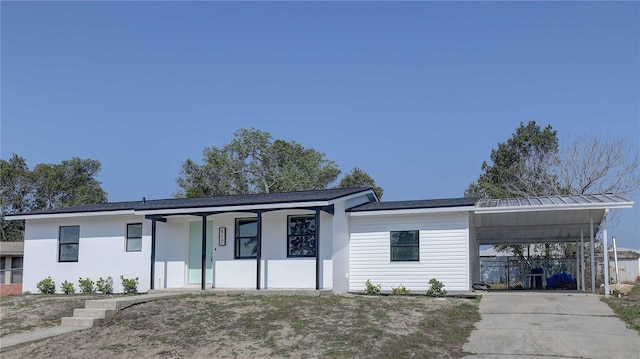 view of front of property featuring a carport, fence, and driveway