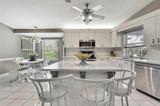 3943 W Fieldwood Ct, Lecanto, FL 34461 - kitchen with stainless steel appliances, a sink, decorative backsplash, plenty of natural light, and a textured ceiling