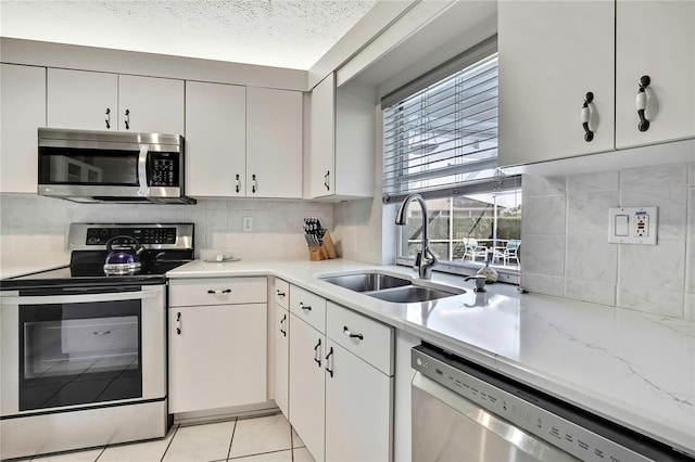 3943 W Fieldwood Ct, Lecanto, FL 34461 - kitchen with stainless steel appliances, a sink, tasteful backsplash, white cabinetry, and a textured ceiling