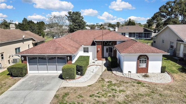 3943 W Fieldwood Ct, Lecanto, FL 34461 - view of front of house with concrete driveway, a garage, roof with shingles, central AC unit, and a front yard