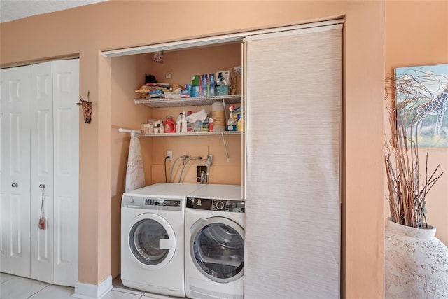 laundry area with light tile patterned floors, laundry area, and washing machine and dryer