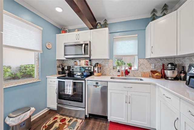 kitchen with a wealth of natural light, stainless steel appliances, light countertops, and a sink