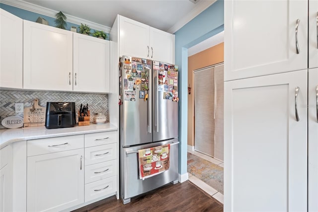 kitchen with white cabinetry, light countertops, tasteful backsplash, and freestanding refrigerator