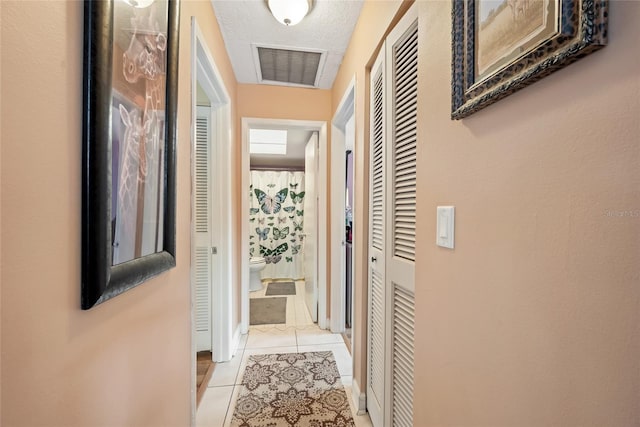 corridor featuring light tile patterned floors and visible vents