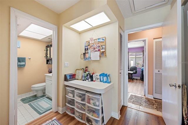 bathroom featuring vanity, toilet, wood finished floors, and baseboards