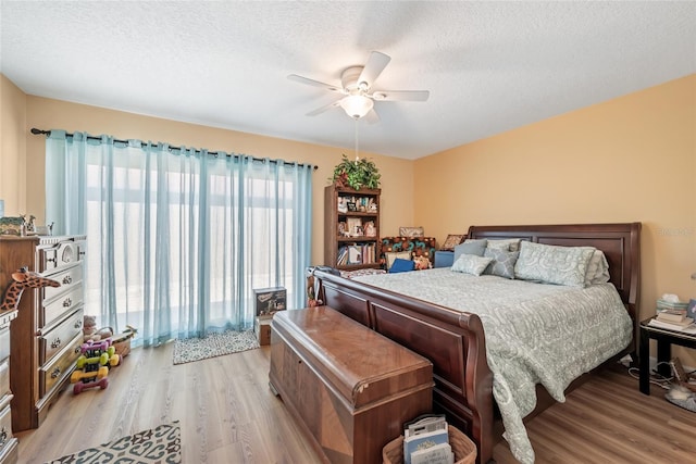 bedroom featuring ceiling fan, a textured ceiling, and light wood-style floors