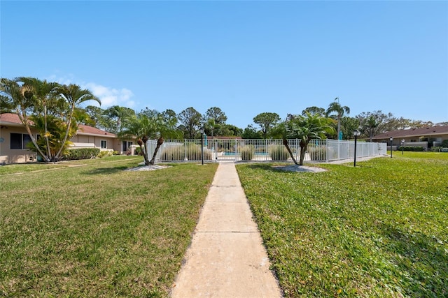 view of property's community featuring a yard and fence