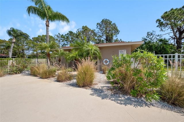 view of front of house with stucco siding and fence