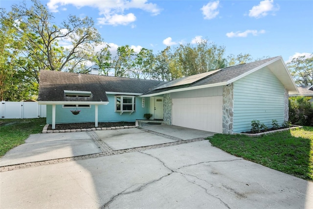 ranch-style house featuring driveway, a gate, fence, a shingled roof, and a garage