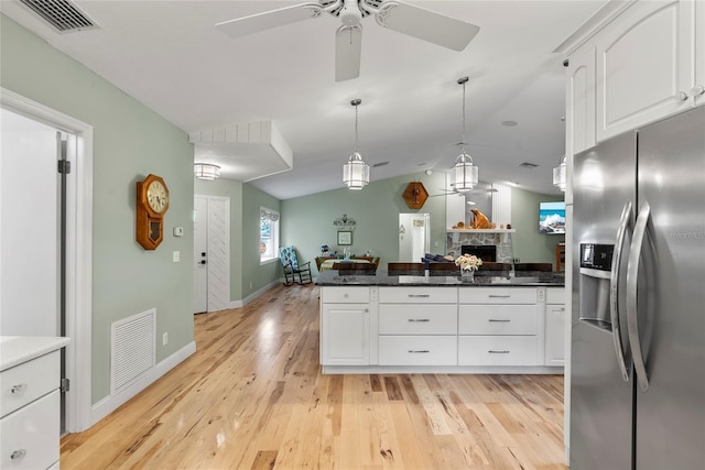 kitchen featuring open floor plan, visible vents, light wood-style flooring, and stainless steel refrigerator with ice dispenser