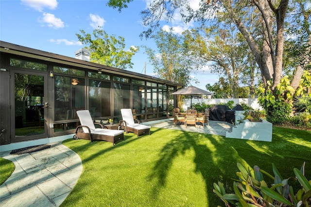 view of yard with a patio area, fence, and a sunroom