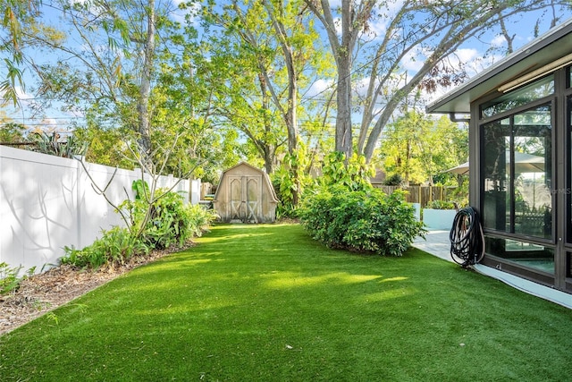 view of yard featuring a fenced backyard, a patio, a storage shed, and an outdoor structure