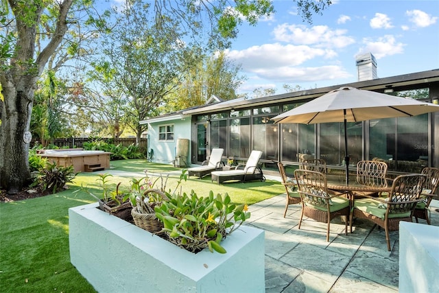 exterior space with a lawn, a hot tub, fence, a sunroom, and a patio area