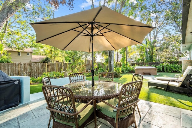 view of patio / terrace featuring outdoor dining space, a fenced backyard, and a hot tub